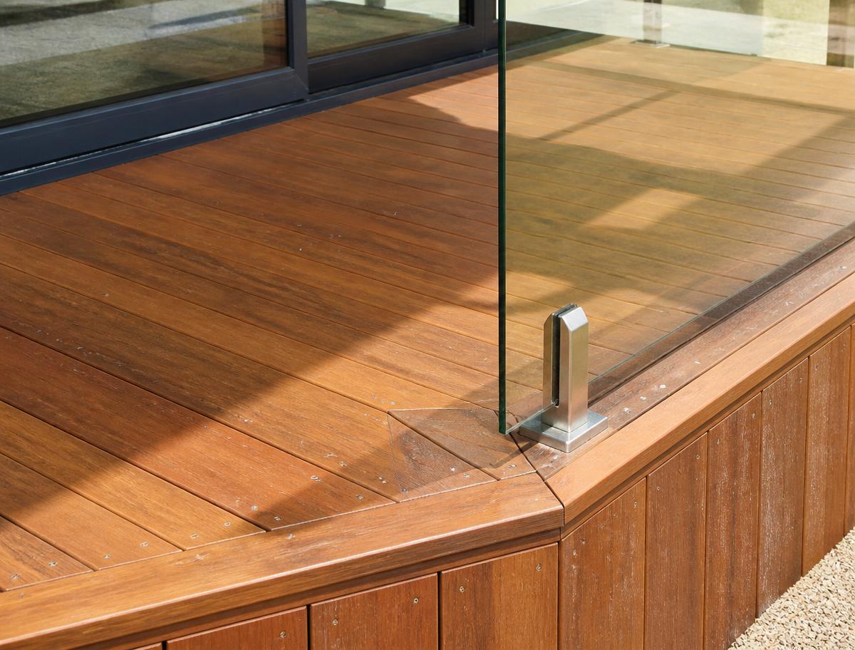 Hardwood deck corner detail with a frameless glass balustrade